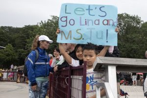 Young children hold up large blue bristol board sign that says "let's go lind and ms. tu!"